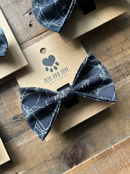 A black pet bow tie with a white spiderweb pattern