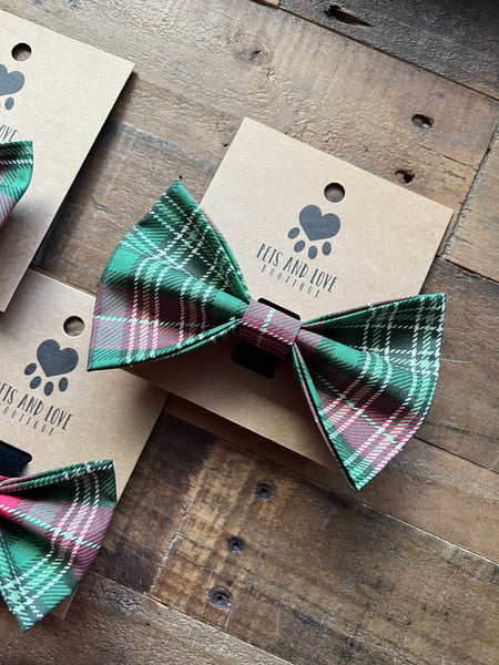 A Extra Large green and red and white plaid pet bow tie displayed on a kraft paper card with the brand name 'Pets and Love Boutique' printed on it, set on a rustic wooden surface.