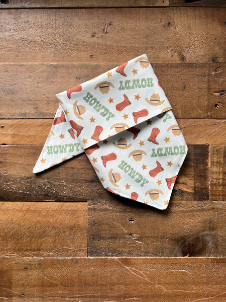 Dog Bandana with cowboy-themed patterns - Green on a wooden surface