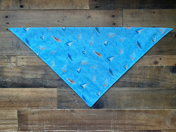 Blue bandana with sailboat pattern on a wooden surface